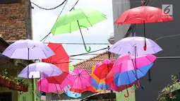 Payung beraneka warna tergantung di sekitar Kampung Warna-Warni, Jalan Bhakti, Cimanggis, Depok, Jawa Barat, Rabu (21/3). Kampung yang dihiasi dengan payung dan cat warna-warni tersebut bertujuan mempercantik lingkungan. (Liputan6.com/Immanuel Antonius)