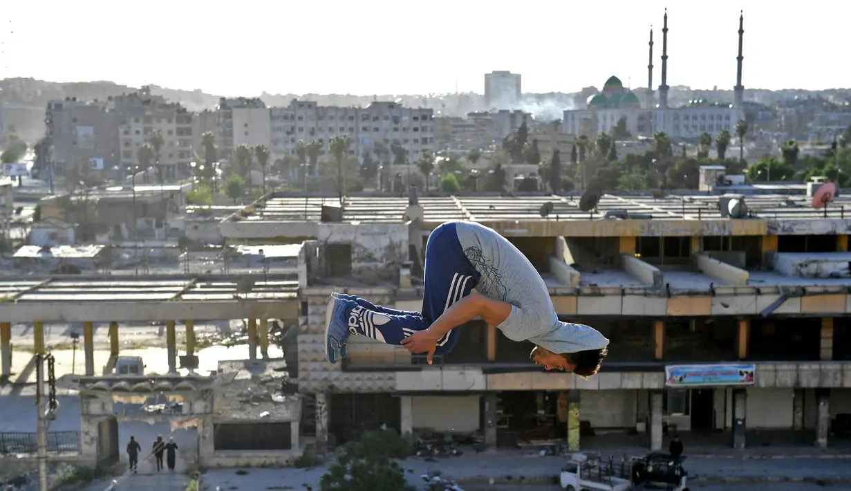 Pemuda Suriah berlatih parkour di Aleppo, Suriah utara, (7/4). Para pemuda memanfaatkan reruntuhan bangunan akibat perang menjadi tempat untuk melatih kelincahannya bermain Parkour. (AFP Photo/George Ourfalian)
