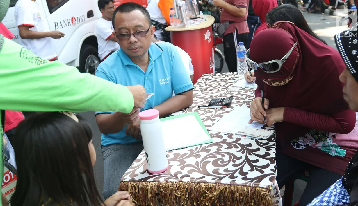 Warga mengisi formulir untuk membayar pajak kendaraan bermotor di gerai Samsat Keliling Car Free Day, Jakarta, Minggu (21/10). Agar bisa membayar pajak ini cukup menggunakan STNK dengan nama yang tertera harus sesuai KTP. (Liputan6.com/Angga Yuniar)