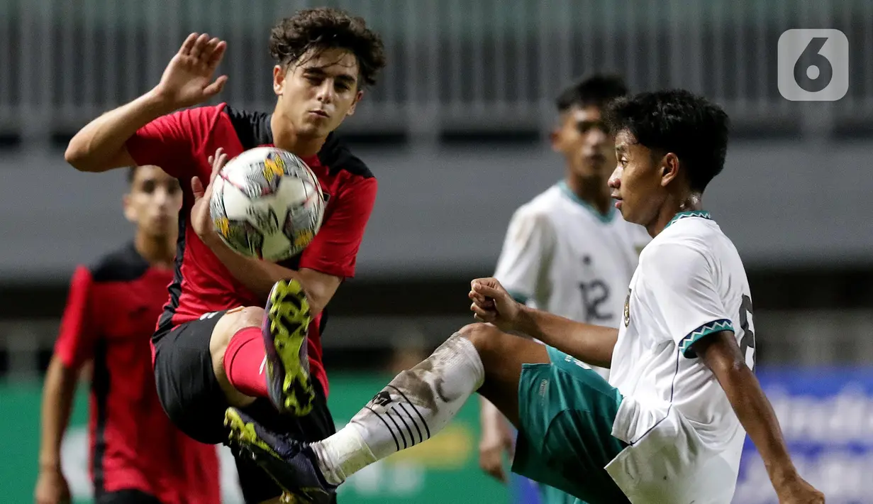 Pemain Timnas U-17 Indonesia, M Hanif Ramadhan (kanan) berebut bola dengan Ahmed Sulaiman (Palestina U-17) pada Kualifikasi Grup B Piala Asia U-17 2023 di Stadion Pakansari, Kab. Bogor, Jawa Barat, Jumat (7/10/2022). Kemenangan atas Palestina menempatkan timnas U-17 Indonesia memuncaki Grup B dengan raihan 9 poin. (Liputan6.com/Helmi Fithriansyah)