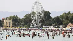 Orang-orang mencari kesegaran saat hari panas dengan suhu lebih dari 40 derajat Celcius di Pantai Mondello, Palermo, Sisilia, Italia, 16 Juli 2023. Suhu diperkirakan akan mencapai rekor tertinggi baru pada minggu ini. (Alberto Lo Bianco/LaPresse via AP)