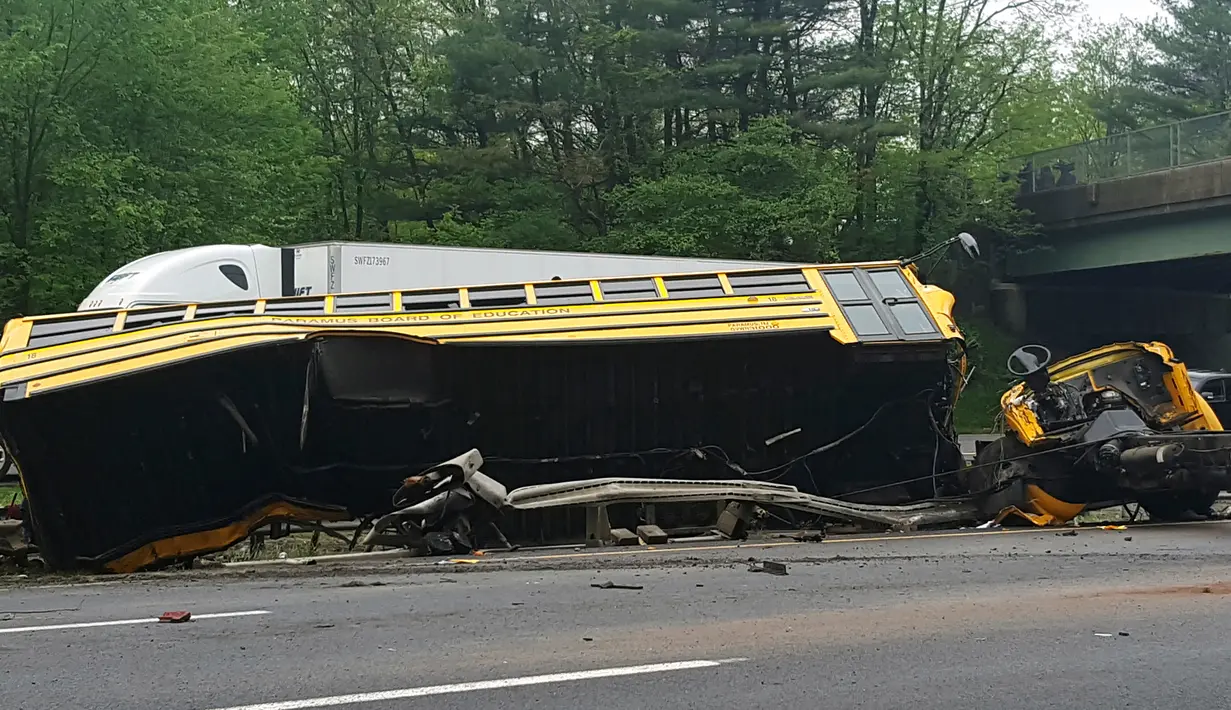 Kondisi bus sekolah yang terbalik setelah bertabrakan dengan truk sampah di Interstate 80, Mount Olive, New Jersey, Kamis (17/5). Bus membawa siswa kelas V East Brook Middle School di Paramus, menuju Waterloo untuk karyawisata. (Chrissy Oleszek via AP)