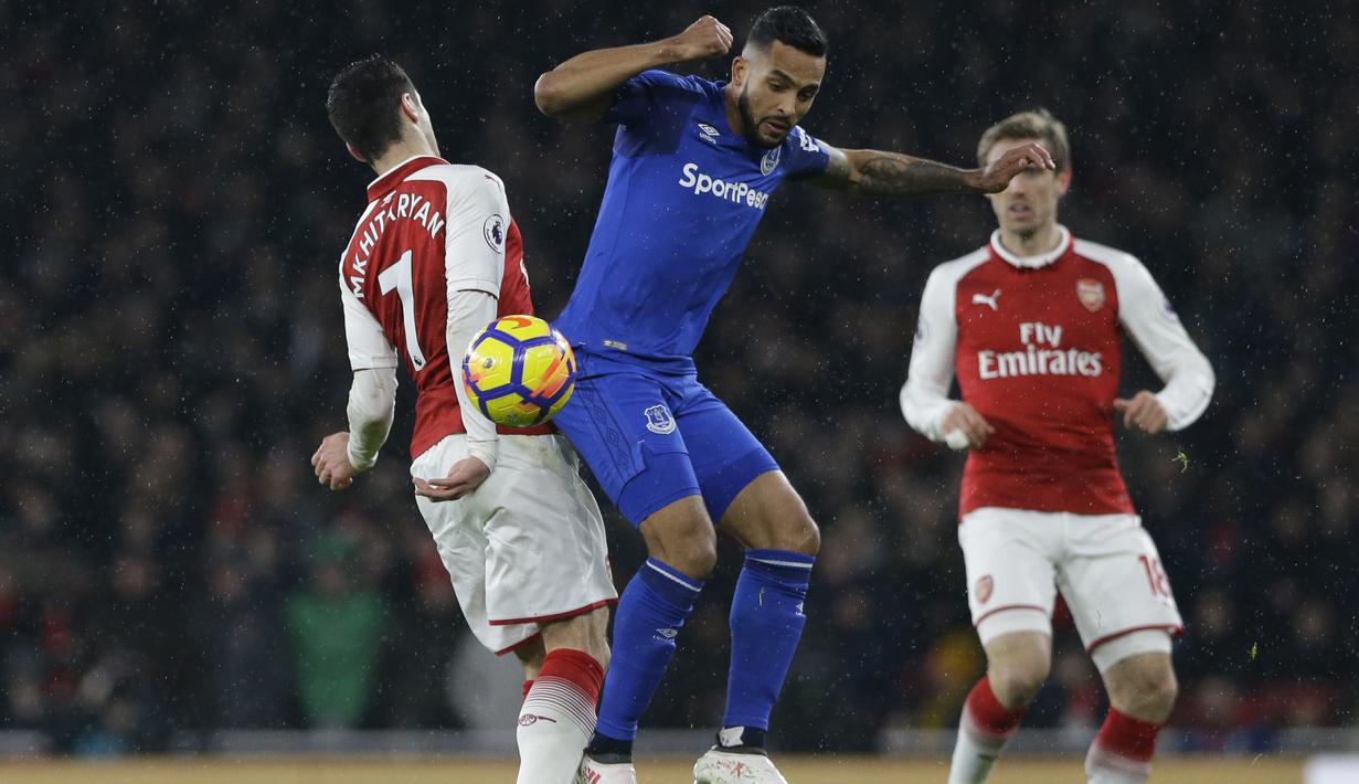 Aksi pemain Arsenal, Henrikh Mkhitaryan (kiri) berebut bola dengan pemain Everton, Theo Walcott pada laga Premier League di Emirates Stadium, London, (3/2/2018). Arsenal menang 5-1. (AP/Alastair Grant)
