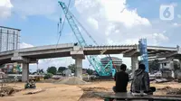 Warga menyaksikan proyek pembangunan Jalan Tol Bekasi-Cawang-Kampung Melayu (Becakayu) Seksi 1, D.I Panjaitan, Jakarta, Kamis (18/11/2021). BPJT mendata hingga akhir kuartal III/2021 perkembangan pembangunan Tol Becakayu Seksi 1 saat ini mencapai 95,54 persen. (merdeka.com/Iqbal S Nugroho)