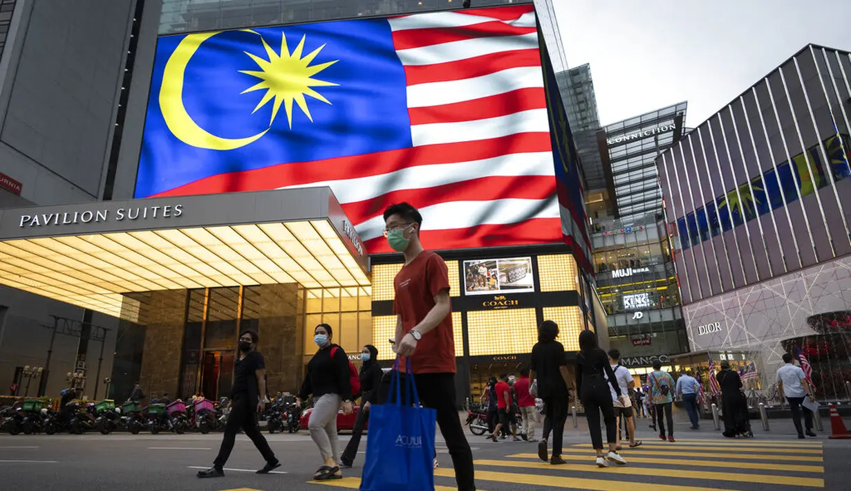 <p>Orang-orang yang memakai masker menyeberang jalan di luar pusat perbelanjaan, di tengah wabah COVID-19 di Kuala Lumpur, Malaysia, Selasa (14/9/2021). Kementerian Kesehatan Malaysia melaporkan total kasus Covid-19 mencapai 2.011.440 pada hari ini, Selasa (14/9). (AP Photo/Vincent Thian)</p>