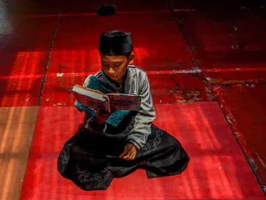 Salah satu santri membaca Al Quran saat tadarus massal di Pondok Pesantren Modern Daarut Tarqiyah Primago, Depok , Jawa Barat, Kamis (6/3/2025). (merdeka.com/Arie Basuki)