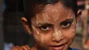 Seorang bocah berpose mengenakan pakaian baru pada perayaan Idul Adha di kamp pengungsi Thangkhali, Bangladesh, Rabu (22/8). Hampir setahun mereka menghuni kamp ini usai kabur menghindari represi militer di Negara Bagian Rakhine. (Dibyangshu SARKAR / AFP)