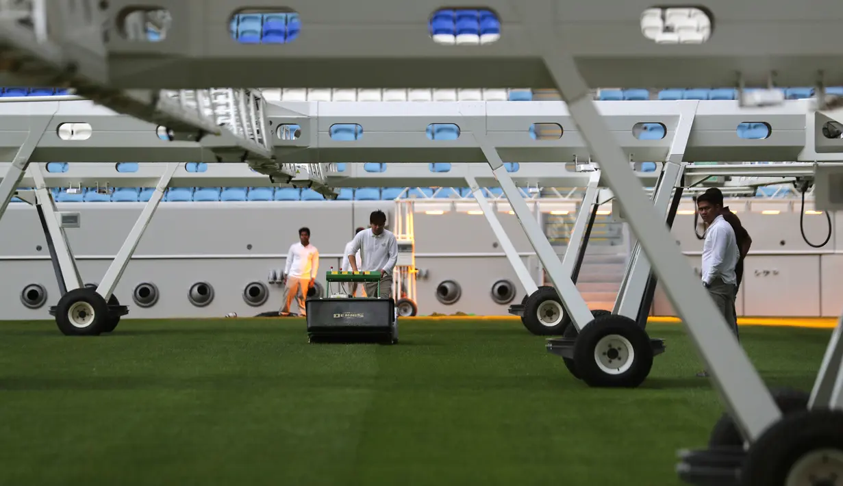 Pekerja mengurus lapangan Stadion Al Janoub di Doha, Qatar, Senin (16/12/2019). Stadion Al Janoub dirancang oleh Zaha Hadid. (AP Photo/Hassan Ammar)