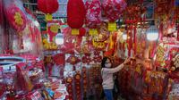 Seorang perempuan membeli dekorasi untuk merayakan Tahun Baru Imlek di Hong Kong, Minggu (30/1/2022). Tahun Baru China atau Imlek jatuh pada 1 Februari (AP Photo/Vincent Yu)