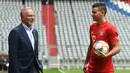 Bek baru Bayern Munchen, Lucas Hernandez berbincang dengan CEO Bayern Munchen, Karl-Heinz Rummenigge saat dirinya diperkenalkan secara resmi di Allianz Arena, Munich, Senin (8/7/2019). Pemain 23 tahun ini diikat kontrak selama lima tahun atau hingga 2024 oleh Bayern Munchen. (Christof STACHE/AFP)