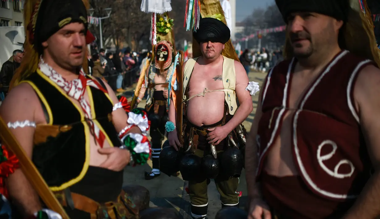 Sejumlah pria mengenakan kostum saat mengikuti Festival Internasional Masquerade Games di Pernik, Bulgaria (28/1). Para peserta selain mengenakan topeng dan kostum mereka juga membawa lonceng. (AFP/Nikolay Doychinov)