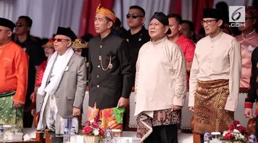 Joko Widodo, capres nomor urut 1, mengenakan pakaian adat Bali,sedangkan Ma'ruf Amin tetap dengan pakaian khasnya menggunakan jas dan kain putih dikalungkan di leher serta sarung sebagai bawahannya.
