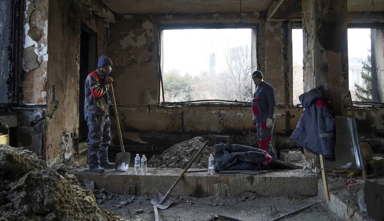 Pekerja kota membersihkan di dalam gedung balai kota yang terbakar di Almaty, Kazakhstan, Kamis (13/1/2022). Aksi protes massal di Kazakhstan dimulai pekan lalu dengan cepat menyebar ke kota terbesar yang juga pusat ekonomi Kazakhstan, Almaty, serta kota-kota lain. (Vladimir Tretyakov/NUR.KZ via AP)