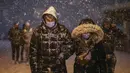Pejalan kaki yang sebagian tertutup salju berjalan dekat jembatan Galata saat salju turun di Istanbul, Turki, Sabtu (12/3/2022). Salju tebal menutupi Istanbul dan mengganggu lalu lintas udara menyebabkan transportasi laut serta darat terhenti, hingga memaksa penutupan sekolah. (AP Photo/Emrah Gurel)