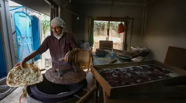 Seorang pencari suaka memasak roti di tempat penampungan sementara, Kalideres, Jakarta Barat, Kamis (15/8/2024). (merdeka.com/Arie Basuki)