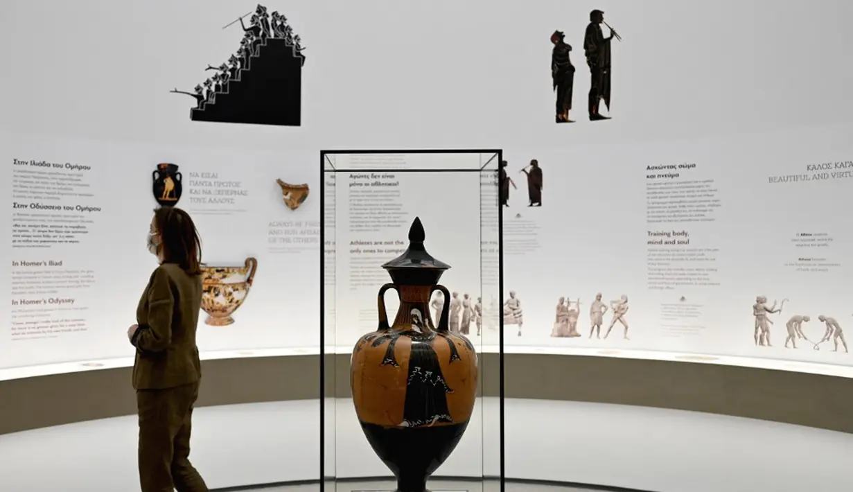 Seorang wanita melihat pameran Museum Olimpiade Athena yang baru pada 25 Mei 2021. Tempat lahirnya Olimpiade modern, Athena, akhirnya memiliki museum Olimpiadenya. (Aris MESSINIS/AFP)
