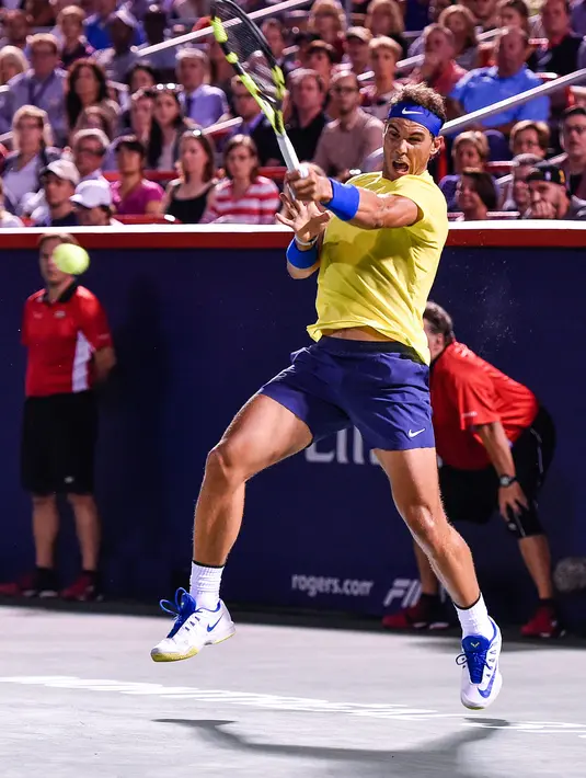 Petenis Spanyol, Rafael Nadal berusaha mengembalikan bola ke arah petenis Kanada, Denis Shapovalov pada turnamen Piala Rogers di Montreal, Kamis (10/8). Nadal disingkirkan petenis 18 tahun dengan skor 6-3, 4-6, 6-7. (MINAS PANAGIOTAKIS/GETTY IMAGES/AFP)