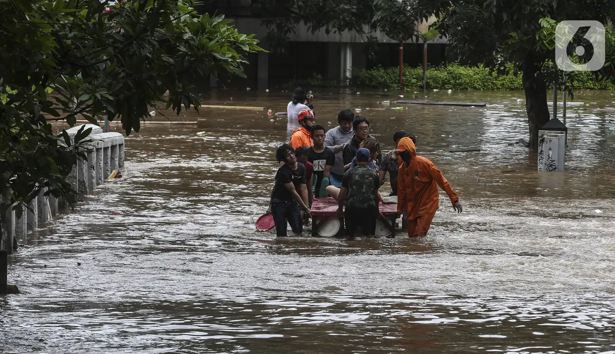 Petugas mengevakuasi warga yang terjebak banjir di kawasan Kemang, Jakarta, Sabtu (20/2/2021). Curah hujan yang tinggi menyebabkan kawasan tersebut terendam banjir setinggi orang dewasa. (Liputan6.com/Johan Tallo)
