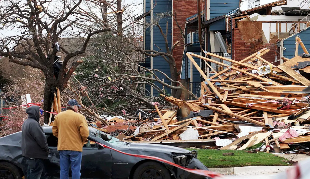 Warga saat melihat reruntuhan rumah yang disapu oleh angin tornado di Texas, Amerika Serikat, (28/12). Bencana ini juga menewaskan 8 orang yang sedang berkendara di jalanan kota Garland. (REUTERS/Todd Yates)