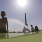 Turis dan warga masuk ke dalam kolam Trocadero Fountains (air mancur Trocadero) dekat Menara Eiffel di Paris, Kamis (25/7/2019). Gelombang panas di Eropa mencapai puncaknya, bahkan suhu di ibu kota Prancis mencapai di atas 41 derajat Celcius. (Dominique FAGET / AFP)