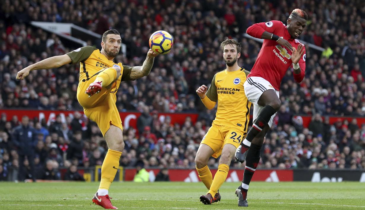 Pemain Brighton, Shane Duffy menghalau bola dari kejaran pemain Manchester United, Paul Pogba pada lanjutan Premier League di Old Trafford, Manchester,(25/11/2017). Manchester United menang tipis 1-0. (Martin Rickett/PA via AP)
