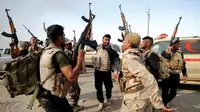 Sejumlah pasukan keamanan Irak bergembira merayakan keberhasilan merebut desa Khalidiya dari ISIS di, selatan Mosul, Irak, (20/10). (REUTERS/Thaier Al-Sudani)