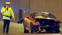 A policeman walks past a crashed ferrari car belonging to Manchester United&#039;s Cristiano Ronaldo in a tunnel near Manchester Airport in Manchester, northwest England,/ANDREW YATES 
