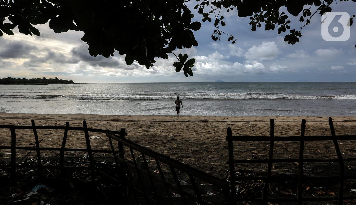 Seseorang terlihat di pantai Carita, Pandeglang, Banten, Selasa (18/1/2022). Objek wisata Pantai Carita yang menjadi tempat favorit pengunjung kini tampak sepi seusai gempa beberapa waktu lalui dan juga lantaran naikknya kasus virus covid 19 varian omicron. (Liputan6.com/Johan Tallo)