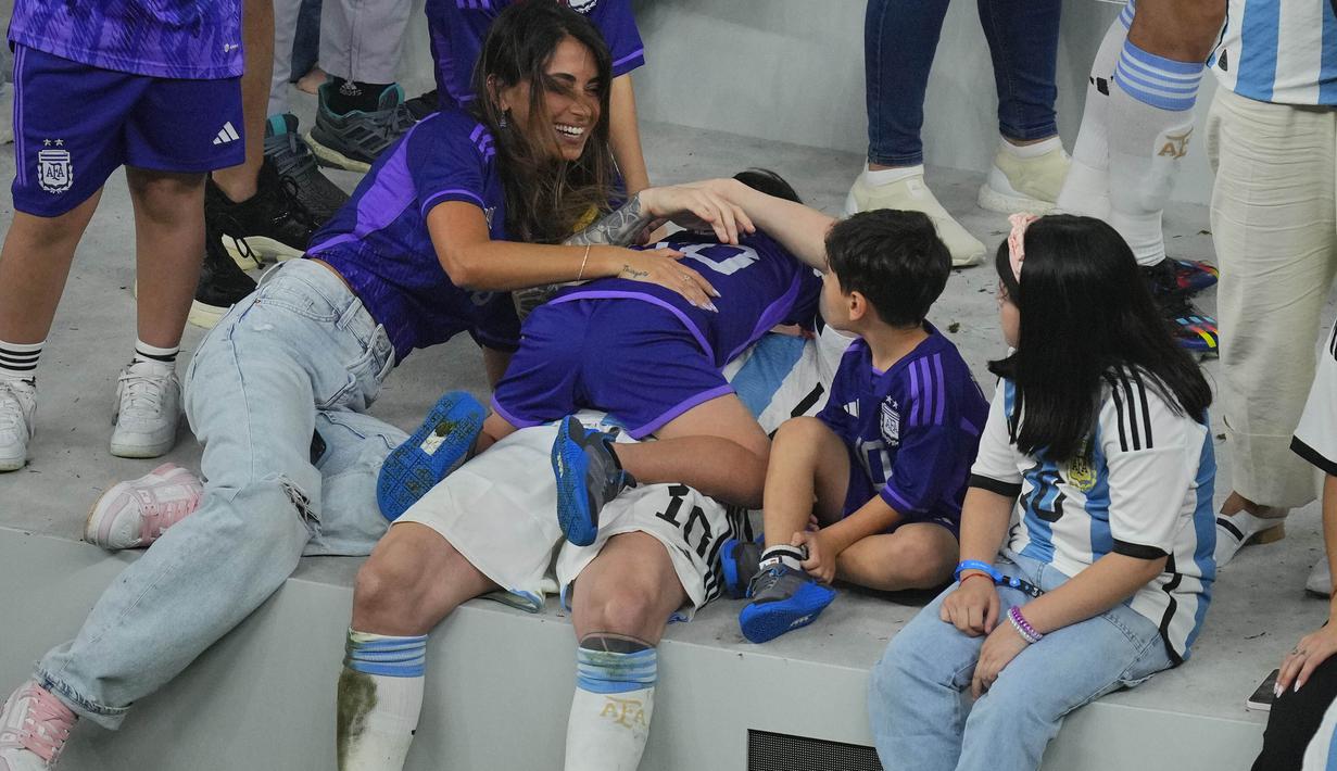 Pemain Argentina, Lionel Messi merayakan kemenangan timnya di Piala Dunia 2022 bersama keluarganya setelah mengalahkan Prancis pada laga final yang berlangsung di Lusail Stadium, Qatar, Minggu (18/12/2022). Albiceleste menang 4-2 atas Prancis di babak penalti. (AP Photo/Hassan Ammar)