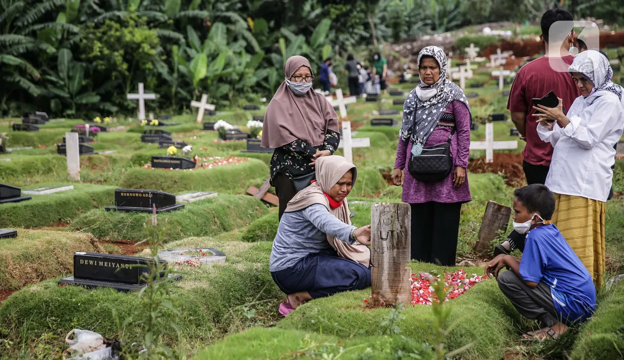 Umat Muslim menabur bunga saat di makam keluarga saat berziarah di Tempat Pemakaman Umum (TPU) Pondok Ranggon, Jakarta, Minggu (04/04/21). Meskipun di tengah pandemi Covid-19 warga tetap melakukan tradisi ziarah kubur. menjelang bulan Ramadan. (Liputan6.com/Faizal Fanani)