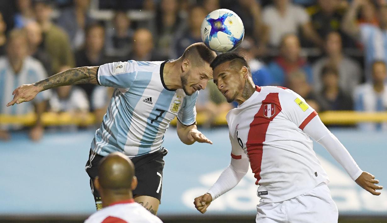 Duel pemain Argentina, Dario Benedetto dan pemain Peru, Miguel Trauco (kanan) pada laga Kualifikasi Piala Dunia 2018 di Buenos Aires, (5/10/2017). Argentina bermain imbang 0-0 lawan Peru. (AFP/Eitan Abramovich)