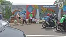 Pejalan kaki dan warga melintasi mural yang berisi pesan ajakan untuk menjaga lingkungan di Jalan Tambak, Manggarai, Jakarta, Selasa (11/2/2020). Mural tersebut bertujuan mengingatkan bahwa permasalahan lingkungan merupakan masalah serius yang harus dihadapi bersama. (Liputan6.com/Herman Zakharia)