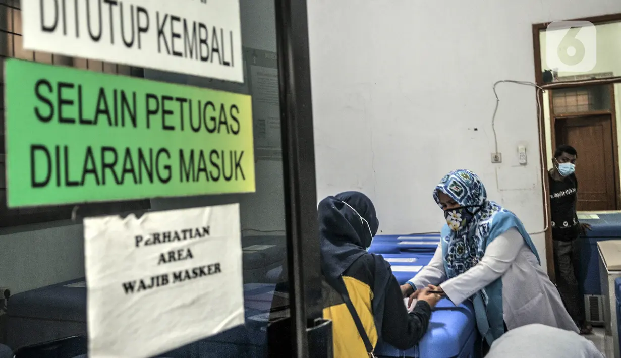 Petugas mendata vaksin COVID-19 produksi Sinovac di gudang penyimpanan UPTD Instalasi Farmasi Dinas Kesehatan Kota Bekasi, Jawa Barat, Selasa (12/1/2021). Vaksin Sinovac yang datang langsung disimpan di lemarin pendingin bersuhu kisaran 2-8 derajat celsius. (merdeka.com/Iqbal S. Nugroho)
