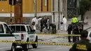 Polisi Kolombia dan ahli forensik memeriksa lokasi ledakan di dekat arena adu banteng Plaza Santamaria di pusat kota Bogota, Minggu (19/2). Sebagian besar korban adalah polisi yang tengah bertugas untuk mengamankan demonstrasi. (AP Photo/Ricardo Mazalan)