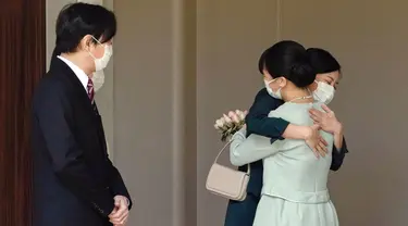 Putri Mako dari Jepang memeluk saudara perempuannya Putri Kako sebelum meninggalkan rumahnya di Istana Akasaka, Tokyo, Selasa (26/10/2021). Putri Mako secara resmi kehilangan status kerajaannya setelah menikahi kekasih semasa kuliah, Kei Komuro pada Selasa (26/10). (Koki Sengoku/Kyodo News via AP)