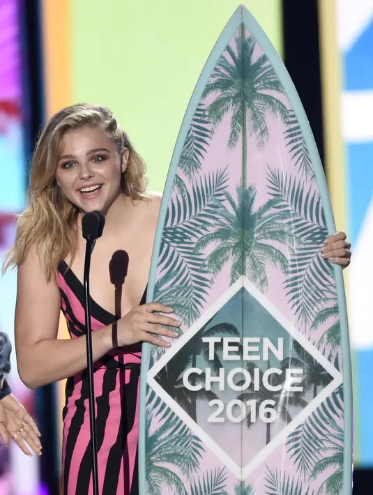 Sambil memegang piala berbentuk papan selancar Chloe Moretz menerima penghargaan sebagai aktris film pilihan: komedi dalam (Neighbors 2: Sorority Rising) (Foto:Chris Pizzello/AP/Bintang.com)