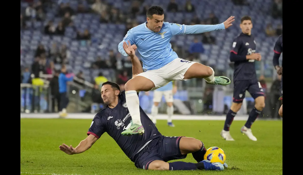 <p>Pemain Lazio, Pedro (kanan) berebut bola dengan pemian Cagliari, Edoardo Goldaniga pada laga pekan ke-14 Liga Italia 2023/2024 di Olympic Stadium, Roma, Italia 2 Desember 2023 waktu setempat. Lazio menang dengan skor tipis 1-0. (AP Photo/Andrew Medichini)</p>