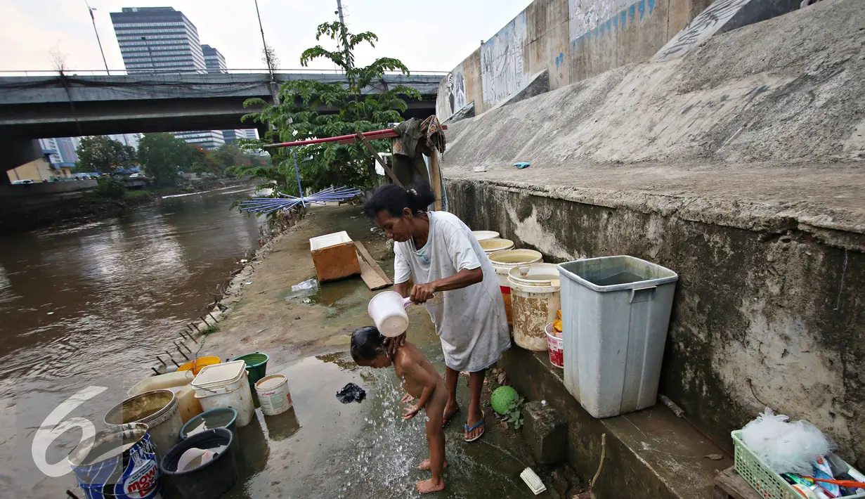 Seorang anak saat mandi di dekat sungai di kawasan Latuharhari, Jakarta Pusat, Selasa (1/12). PAM Jaya menyatakan pasokan air baku yang ada di Jakarta masih belum memungkinkan untuk diolah menjadi sumber air baku utama. (Liputan6.com/Immanuel Antonius)