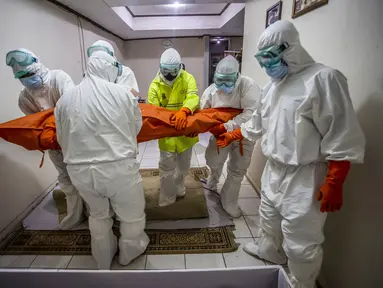 Tim penanganan bersiap membawa jenazah  pasien Covid-19 yang meninggal di rumah selama isolasi mandiri setelah rumah sakit setempat tidak dapat menampung pasien virus corona di Bogor, Jawa Barat (6/7/2021).  (AFP/ Aditya Aji)