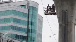 Dua pekerja tengah memasang pipa saluran air di jalan layang khusus TransJakarta Tendean-Ciledug, di Jakarta, Kamis (24/22). Proyek pembangunan jalan layang Transjakarta Koridor XIII Tendean-Ciledug sudah hampir rampung. (Liputan6.com/Helmi Afandi)