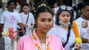 Seorang wanita menusuk pipinya dengan besi  saat mengikuti prosesi perayaan Festival Vegetarian tahunan di Phuket, Thailand, Kamis (3/10/2019). Festival dimulai pada malam pertama bulan lunar kesembilan dan berlangsung selama sembilan hari. (AFP Photo/Mladen Antonov)