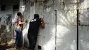 Petugas melakukan pengintaian rumah terduga penampung TKI Ilegal di Jalan Percetakan Negara X, Jakarta, Rabu (31/5). Dengan membawa satu tersangka, petugas Dirtipidum Mabes Polri melakukan pencarian barang bukti baru. (Liputan6.com/Helmi Fithriansyah)