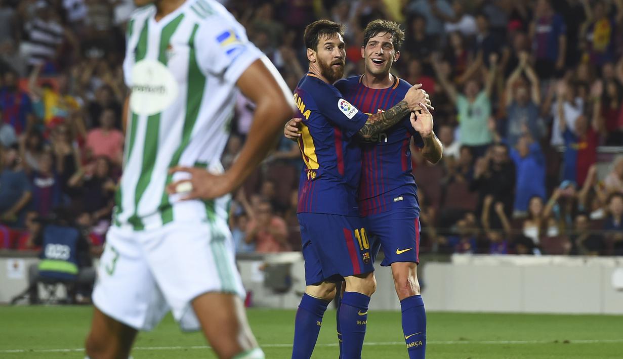 Lionel Messi dan Sergi Roberto (kanan) merayakan gol ke gawang Real Betis pada  laga La Liga Spanyol di Camp Nou stadium, Barcelona, (20/8/2017). Barcelona menang 2-0. (AFP/Josep Lago)