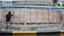 Petugas Penanganan Prasaranan dan Sarana Umum (PPSU) menyelesaikan pembuatan mural di Jalan RE Martadinata, Tanjung Priok, Jakarta Utara, Selasa (24/5/2022). Pembuatan mural di sepanjang Jalan RE Martadinata yang dilakukan oleh petugas PPSU dari 19 kelurahan di Jakarta Utara tersebut dalam rangka menyambut balapan Formula E dan HUT ke-495 Kota Jakarta. (merdeka.com/Iqbal S Nugroho)