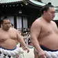 Pegulat sumo Hakuho (depan) dan Kakuryu (kiri) dari Mongolia berjalan dengan para pegulat sumo lainnya setelah berdoa di Kuil Yasukuni di Tokyo, Jepang, Senin (17/4). (AP Photo / Shizuo Kambayashi)