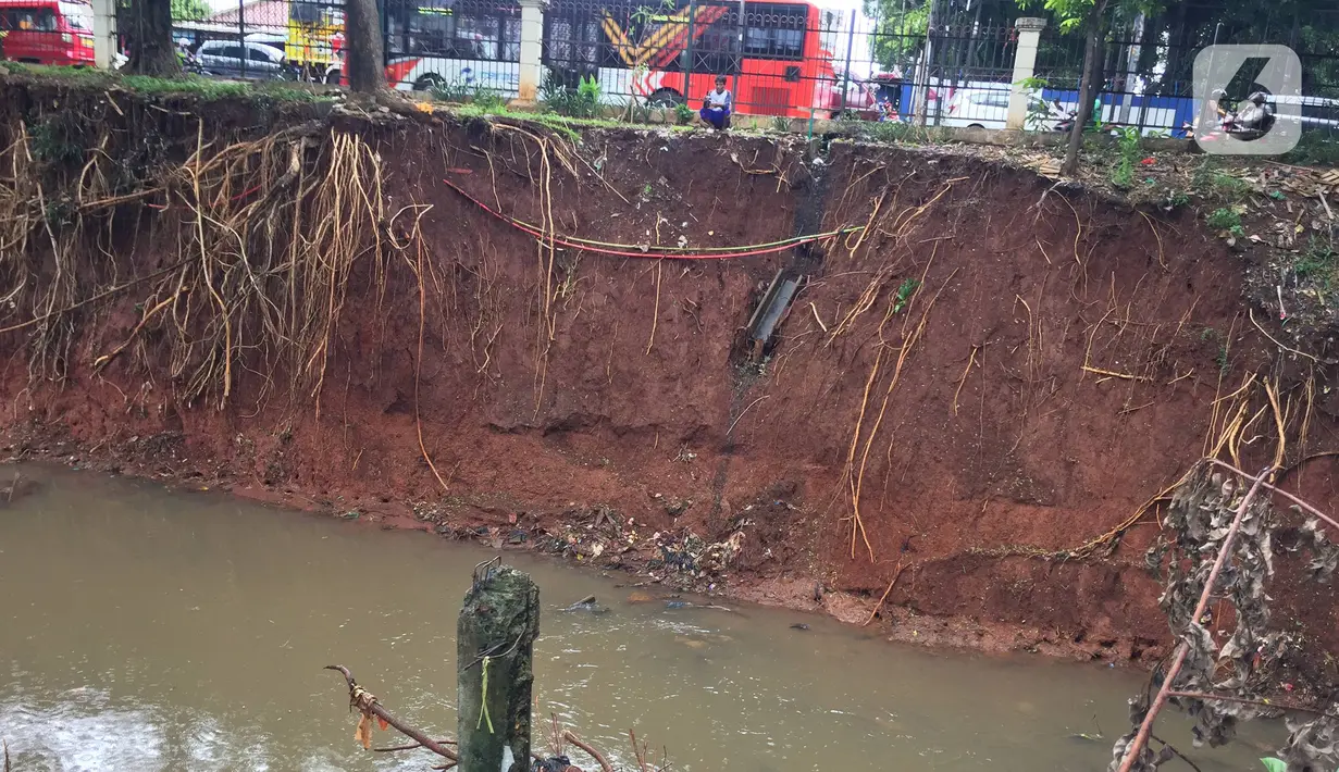 Kondisi dinding Kali Baru yang longsor di Jalan Raya Bogor, Kramat Jati, Jakarta Timur, Jumat (10/1/2020). Longsor yang terjadi akibat banjir beberapa waktu lalu tersebut berpotensi menyebabkan longsor susulan akibat tidak adanya turap yang menahan dinding kali. (Liputan6.com/Immanuel Antonius)