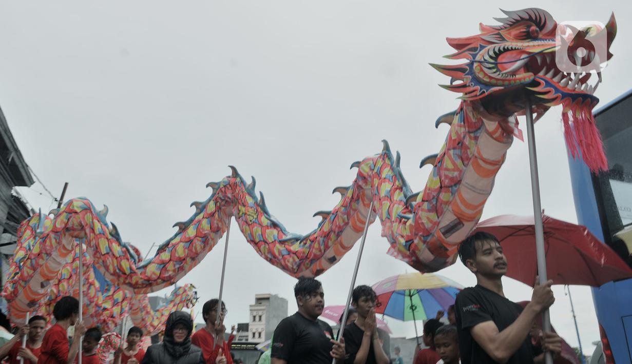 Atraksi liong saat perayaan Cap Go Meh Tahun Baru Imlek 2571 di Jatinegara, Jakarta, Minggu (9/2/2020). Meski hujan, perayaan Cap Go Meh berlangsung meriah dengan atraksi barongsai dan liong serta arakan dewa-dewa (rupang), mengelilingi kawasan Jatinegara. (merdeka.com/Iqbal S Nugroho)
