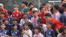 Wataru Endo, Yuto Nagatomo, dan sejumlah pemain Jepang bersiap foto bersama dengan sejumlah anak-anak yang tergabung ke dalam sekolah sepak bola Jakarta Japan Club (JJC) sebelum sesi latihan yang berlangsung di Lapangan A, Senayan, Jakarta, Selasa (12/11/2024). (Bola.com/Bagaskara Lazuardi)