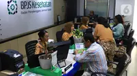 Petugas melayani peserta di Kantor BPJS Kesehatan, Jakarta, Selasa (10/3/2020). Mahkamah Agung (MA) membatalkan kenaikan iuran BPJS Kesehatan setelah mengabulkan sebagian permohonan uji materi terhadap Perpres Nomor 75 Tahun 2019 tentang Jaminan Kesehatan. (Liputan6.com/Angga Yuniar)