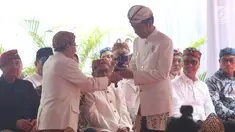 Presiden Joko Widodo (Jokowi) menerima kujang, senjata khas Sunda dalam prosesi penganugerahan gelar Pinisepuh dari Paguyuban Pasundan di Bandung, Minggu (11/11). Paguyuban Pasundan adalah ormas Sunda yang berdiri sejak 1913. (Liputan6.com/Angga Yuniar)